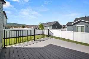 Wooden deck with a mountain view and a lawn