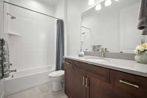 Full bathroom featuring tile patterned flooring, vanity, shower / bath combo, and toilet