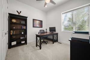 Office space with light carpet and ceiling fan