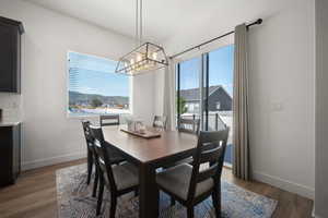 Dining area with a notable chandelier and dark hardwood / wood-style floors