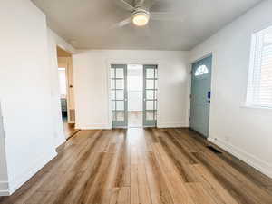 Entrance foyer with a textured ceiling, ceiling fan, and light hardwood / wood-style flooring