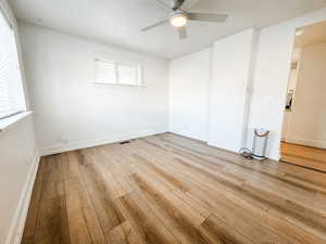 Empty room featuring hardwood / wood-style flooring and ceiling fan