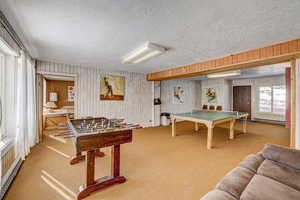 Playroom featuring carpet flooring, a textured ceiling, and baseboard heating