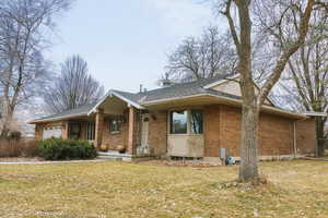 Single story home with a garage and a front lawn