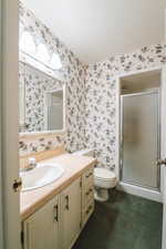 Bathroom with vanity, toilet, a textured ceiling, and walk in shower