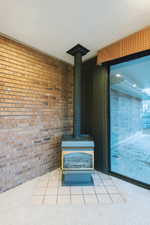 Interior details featuring carpet floors, a wood stove, and a textured ceiling