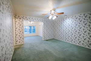 Carpeted empty room with crown molding, ceiling fan, and a textured ceiling