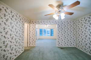 Carpeted spare room with crown molding and a textured ceiling