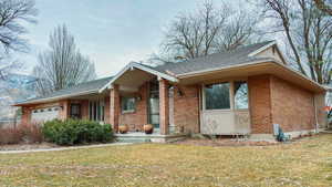 View of front of house featuring a garage and a front lawn