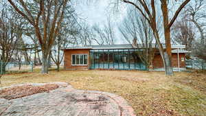 Back of property featuring a yard and a sunroom