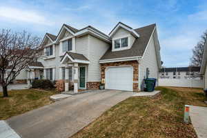 View of front of house with a garage and a front lawn