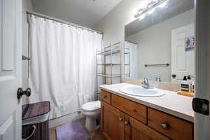 Full bathroom featuring shower / bathtub combination with curtain, vanity, toilet, and tile patterned flooring