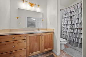 Full bathroom with vanity, vaulted ceiling, toilet, and shower / bath combo with shower curtain