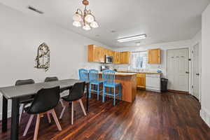 Dining room featuring dark hardwood / wood-style floors and a chandelier