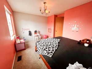 Bedroom with an inviting chandelier and carpet flooring