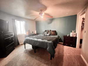 Bedroom with ceiling fan and a textured ceiling