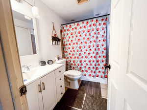 Full bathroom featuring vanity, toilet, tile patterned flooring, and shower / tub combo