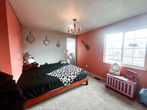 Bedroom featuring carpet flooring and a chandelier