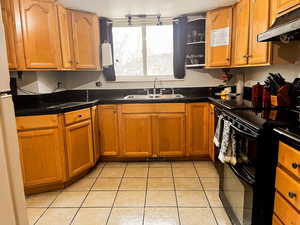 Kitchen with sink, electric range, and light tile patterned floors