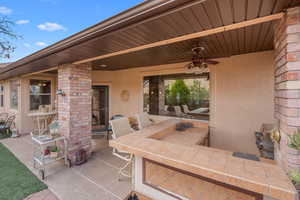 View of patio featuring ceiling fan and exterior bar