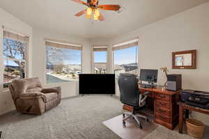 Carpeted office with plenty of natural light and ceiling fan