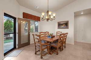 Dining room featuring a notable chandelier and light tile patterned flooring