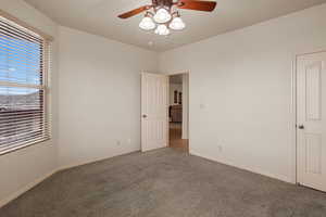 Carpeted empty room with ceiling fan