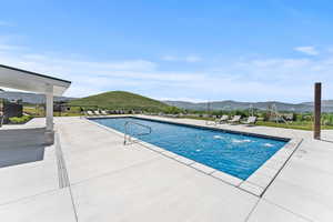 View of swimming pool featuring a mountain view and a patio