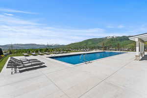 View of pool with a patio and a mountain view