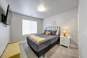 Bedroom featuring light carpet