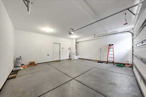 Garage featuring a garage door opener and separate washer and dryer