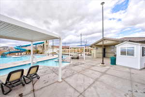 View of swimming pool with an outbuilding, a water slide, and a patio area