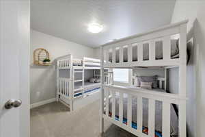 Bedroom with a textured ceiling and carpet