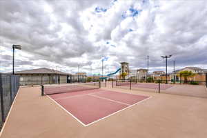 View of tennis court featuring a playground