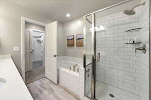 Bathroom with vanity, hardwood / wood-style floors, and plus walk in shower