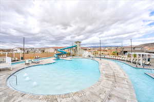 View of swimming pool featuring pool water feature, a water slide, and a patio