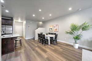 Dining space with sink and dark wood-type flooring