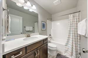 Full bathroom with toilet, vanity, shower / bathtub combination with curtain, and hardwood / wood-style floors