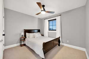 Upstairs  carpeted bedroom with ceiling fan and 3 tone paint.