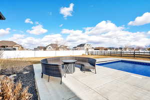 View of swimming pool with a patio area. In the back corner of the fence there is a gate to the side street for easy pull in trailer access.