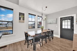 Dining area with an inviting chandelier and plenty of natural light.