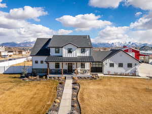 Modern farmhouse style home with a mountain view via drone.