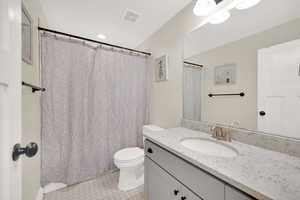 Basement full bathroom featuring vanity, tile patterned floors, and toilet.