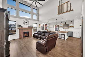 Living room with plenty of natural light, a substantial ceiling fan, and a gas fireplace