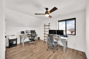 Bedroom with lofted ceiling and composite hardwood LVP flooring. Currently used as an office.