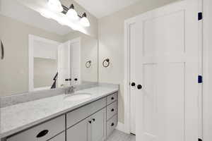 Bathroom featuring large vanity and storage closet