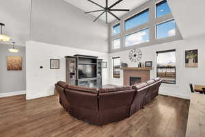 Living room featuring a gas fireplace, and a towering 2-story ceiling allowing for plenty of natural light.