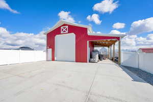 View of extra large barn with carport.