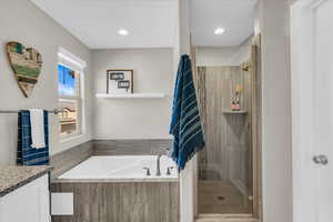 Bathroom featuring vanity and separate shower and tub