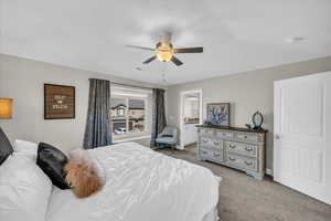 Bedroom with ensuite bathroom, carpet, and ceiling fan